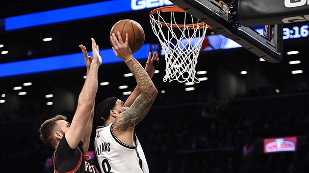 Deron Williams (v blm) z Brooklynu zakonue na ko Portlandu, o blok se pokou Joel Freeland.