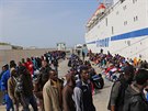 Migranti ekají na ostrov Lampedusa na nastoupení na lo, která je peveze na...