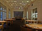 Jednoduchý interiér restaurace zdobí svtelné aplikace na stropu.