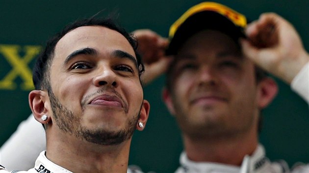 SMV VTZE. Lewis Hamilton na stupnch vtz Velk ceny ny. Za nm stoj druh v cli Nico Rosberg.