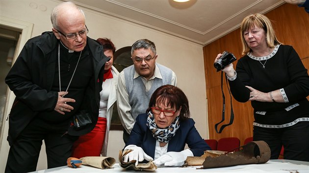 Biskup Frantiek Lobkowicz (vlevo) nahl do dokument ze star schrnky, kter te editelka ostravskho archivu Blaena Przybylov Uprosted far Jan Plaek. (10. dubna 2015)