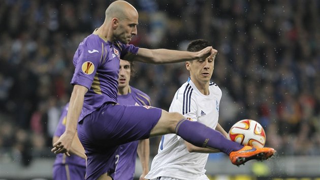 Borja Valero (ve fialovm) z Fiorentiny odkopv m ped Jevgen Chaeridim z Dynama Kyjev.