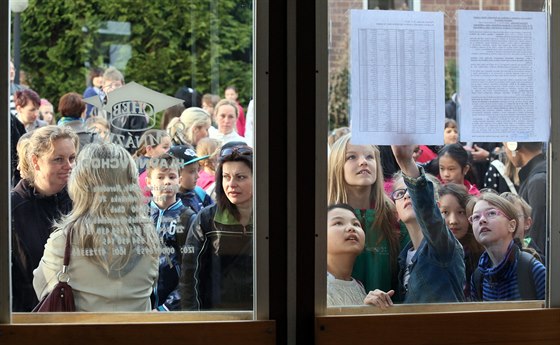 Budoucí studenti hledají svá jména v seznamech na dveřích chebského gymnázia.