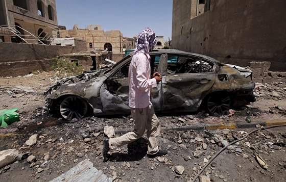 Mu prochází kolem auta, které bylo znieno pi leteckém úderu v Sanaa (21....