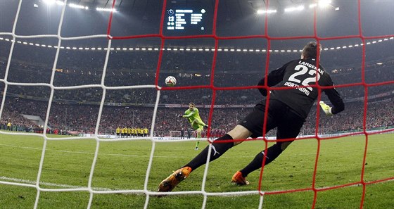 MÍ JDE DO BEVNA. Branká Manuel Neuer kope penaltu proti kolegovi Langerakovi...