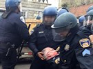 Baltimortí policisté odnáejí zranného kolegu. (27. 4. 2015)