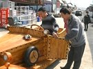 ínský tesa Liu Fulong pedvádí zájemcm svoje devné auto z borového deva.