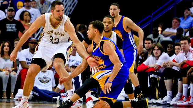 Podklouznut Stephena Curryho z Golden State sleduje Ryan Anderson z New Orleans.