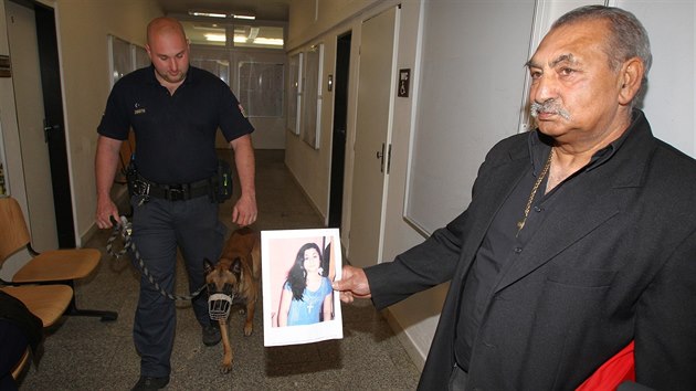 Otec zavražděné ženy s její fotografií před jednací síní krajského soudu