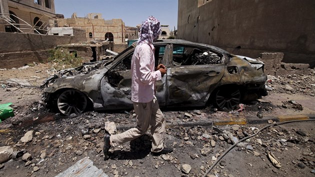 Mu prochz kolem auta, kter bylo znieno pi leteckm deru v Sanaa (21. dubna 2015).
