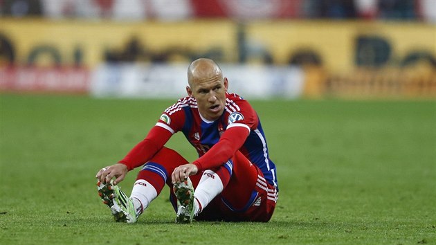 Arjen Robben z Bayernu  smutně sedí na hřišti během semifinále Německého poháru proti Dortmundu. Po měsíční léčbě břišních svalů si znovu zranil, natrhl si lýtkový sval.