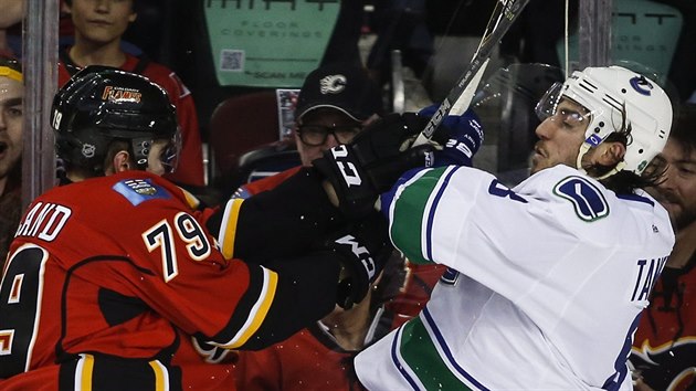 Chris Tanev (vpravo) z Vancouveru a Michael Ferland z Calgary se stetli u mantinelu.