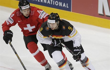 výcarský hokejista Patrick Geering (vlevo) stíhá  Tobiase Riedera z Nmecka.