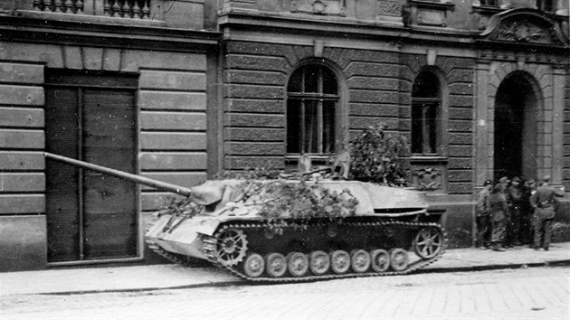 Německý těžký stíhač tanků Jagdpanzer IV v Komenského ulici v Olomouci. Vlevo jedni z posledních vojáků wehrmachtu ve městě. (květen 1945)