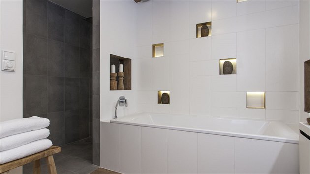 Designi pipojili ke koupeln st vedlej komory a tak  zskali prostor pro velk sprchov kout.