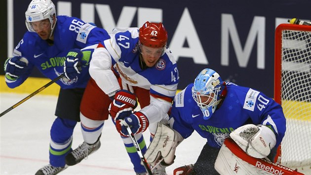 Rusk hokejista Arjom Anisimov se sna prosadit pes Sabahudina Kovaecie ped slovinskho branke Luku Granara.
