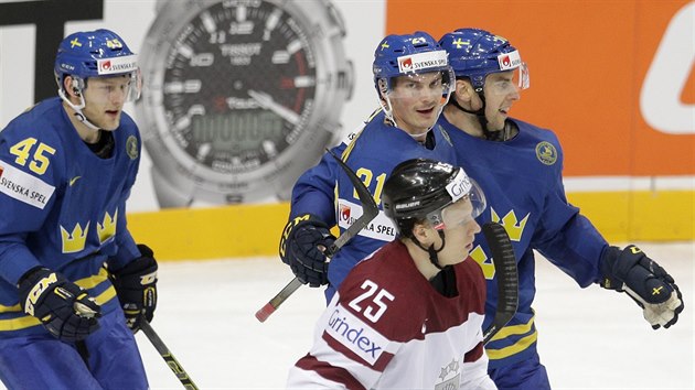 Lotyš Andris Dzerinš projíždí kolem radujících se švédských hokejistů.