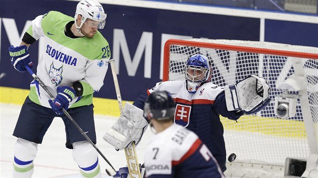 Slovinec Jan Urbas (vlevo) teuje puk za záda slovenského brankáe Jána Laca.