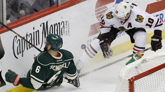 Marco Scandella (vlevo) z Minnesoty a Patrick Sharp z Chicaga kon po vzjemnm souboji na mantinelu.