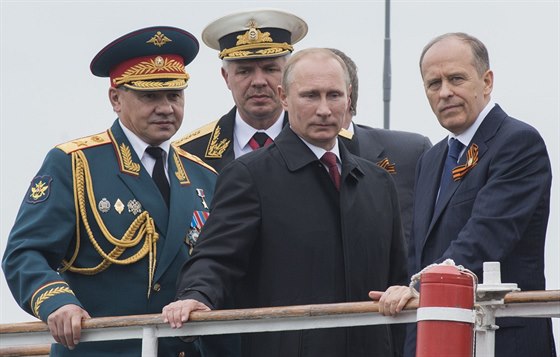 Ruský prezident Vladimir Putin s ministrem obrany Sergejem ojgu (vlevo) a...