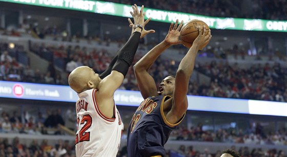 Tristan Thompson z Clevelandu stílí, blokuje ho Taj Gibson z Chicaga.