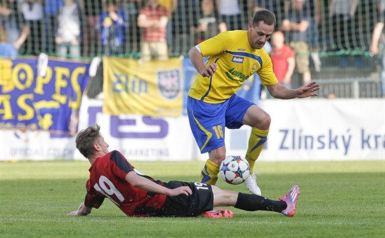 Zlínský fotbalista Robert Matjov se vyhýbá faulu Jakuba Janetzkého z Opavy.