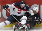 Slovenský hokejista Sersen padá na Ameriana Smithe.