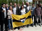 Vít Jedlika (uprosted v saku bez brýlí) s píznivci a vlajkou státu Liberland...