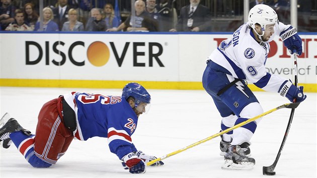 Tyler Johnson napahuje, Martin St. Louis mu jet do rny stihl vloit hokejku.