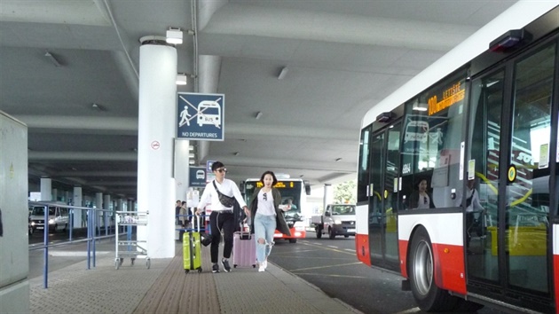 Turisté na zastávce autobus na Letiti Václava Havla.