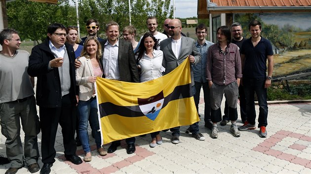 Vít Jedlička (uprostřed v saku bez brýlí) s příznivci a vlajkou státu Liberland (1. května 2015)