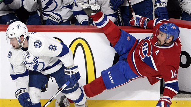 Tom Plekanec (v ervenm) z Montrealu pad po souboji s Tylerem Johnsonem z Tampa Bay.