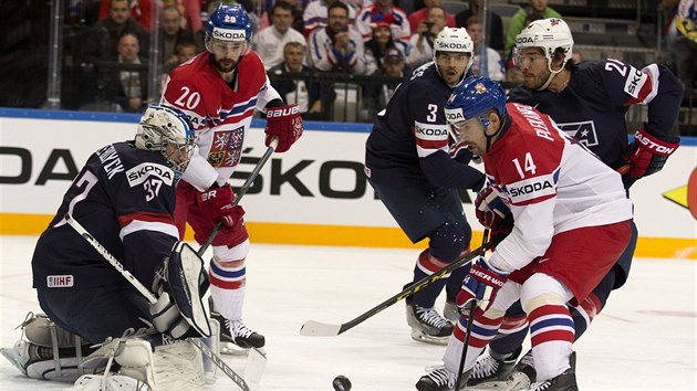 esk tonk Tom Plekanec (s slem 14) v anci v utkn o bronz, na zsah se u chyst americk glman Connor Hellebuyck.