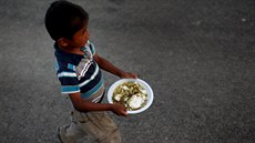 Chlapec v Nepálu si nese jídlo, které obdrel od humanitární organizace (14....