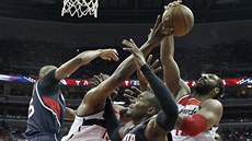 Urputný boj pod ko�em v zápase Washington - Atlanta. Zleva Al Horford z...