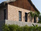 Stavbu obklopuje betonový plot a kee bambusu.