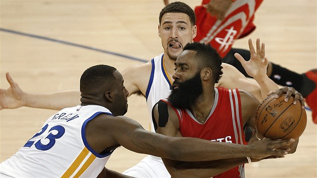 James Harden bojuje s pesilou. Zleva na nj dotr Draymond Green, za nm brn Klay Thompson.