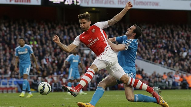 Olivier Giroud z Arsenalu pl, zastavit se ho pokou John OShea ze Sunderlandu.