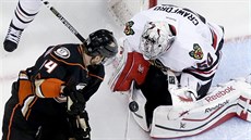 Chicagský branká  Corey Crawford se snaí chytit puk ped Tomáem...