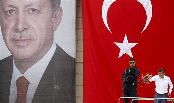 Turecký premiér Davutoglu na setkání s píznivci AKP, za ním turecká vlajka a...