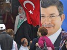 Lidé v Istanbulu u plakátu lídra AKP Ahmeta Davutoglua (5. ervna 2015).