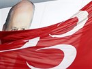 Portér lídra Strany národní akce (MHP) Devleta Bahceliho je vidt za vlajkou...