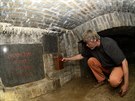 Restaurátor Andrej embera ukládá schránku s listinami a pedmty v podzemí...