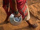 Sakhri, second wife of Sakharam Bhagat, carries an empty metal pitcher as she...