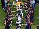 Fotbalisté Juventusu Turín procházejí ulikou hrá Barcelony, kteí jim...