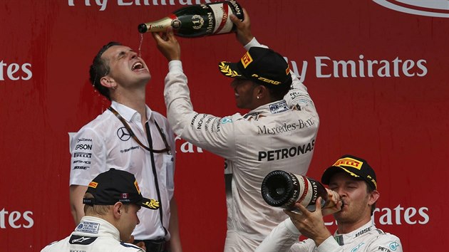Lewis Hamilton rozlv ampus po triumfu ve Velk cen Kanady. Druh v poad Nico Rosberg si dv douek pod dohledem tetho Valtteri Bottase.