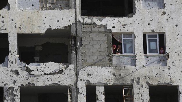 Palestinci vykukuj z ponienho domu v Psmu Gazy (2. ervna 2015).