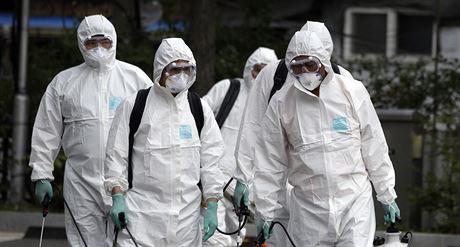 Pracovníci v ochranných oblecích provádjí dezinfekci v jihokorejském Soulu...