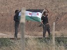 lenové Syrské svobodné armády mávají vlajkou ped Tall Abjad (15. ervna 2015).