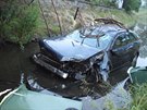 Osobní auto prorazilo zábradlí mostu a skonilo v korytu potoku.